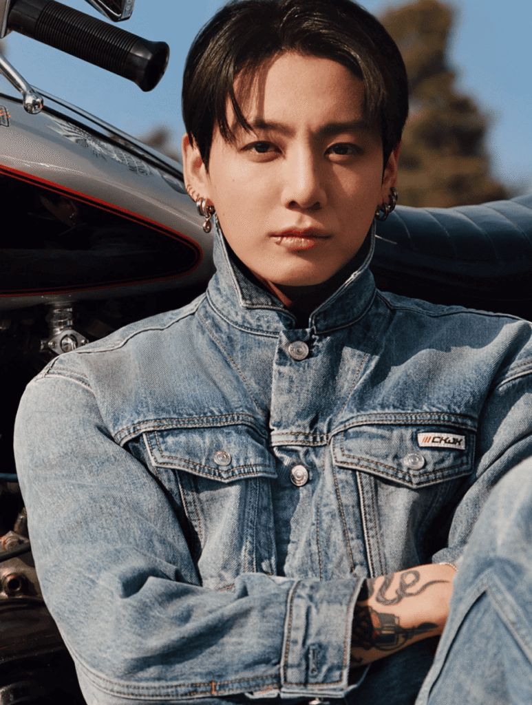 Jungkook posing in a casual denim streetwear look